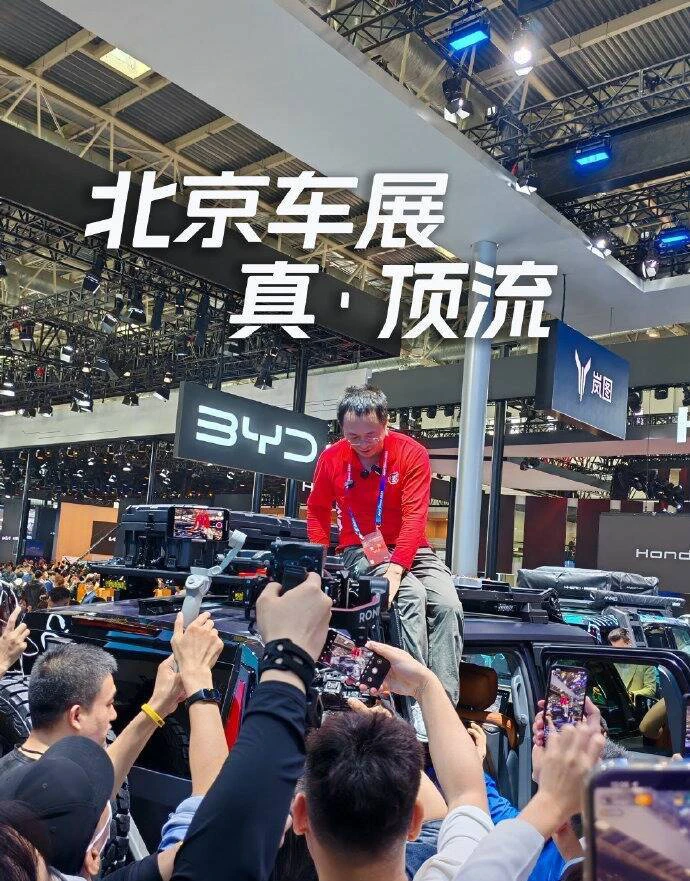 360董事长周鸿祎，在北京车展坐上车顶，引发大量媒体和看展群众围观，一身红色上衣