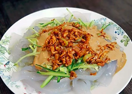 我认为东北必不可少的年夜饭是饺子、红烧肉和东北大拉皮，这些菜肴代表了东北地区的美