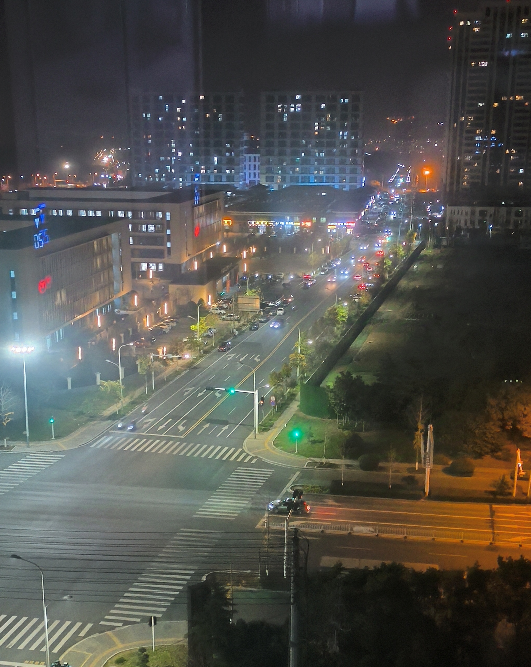 夜晚的城市街道，街灯和车灯交织出一片温暖的光晕，高楼大厦静静矗立，见证着这座不夜城的繁华与喧嚣。