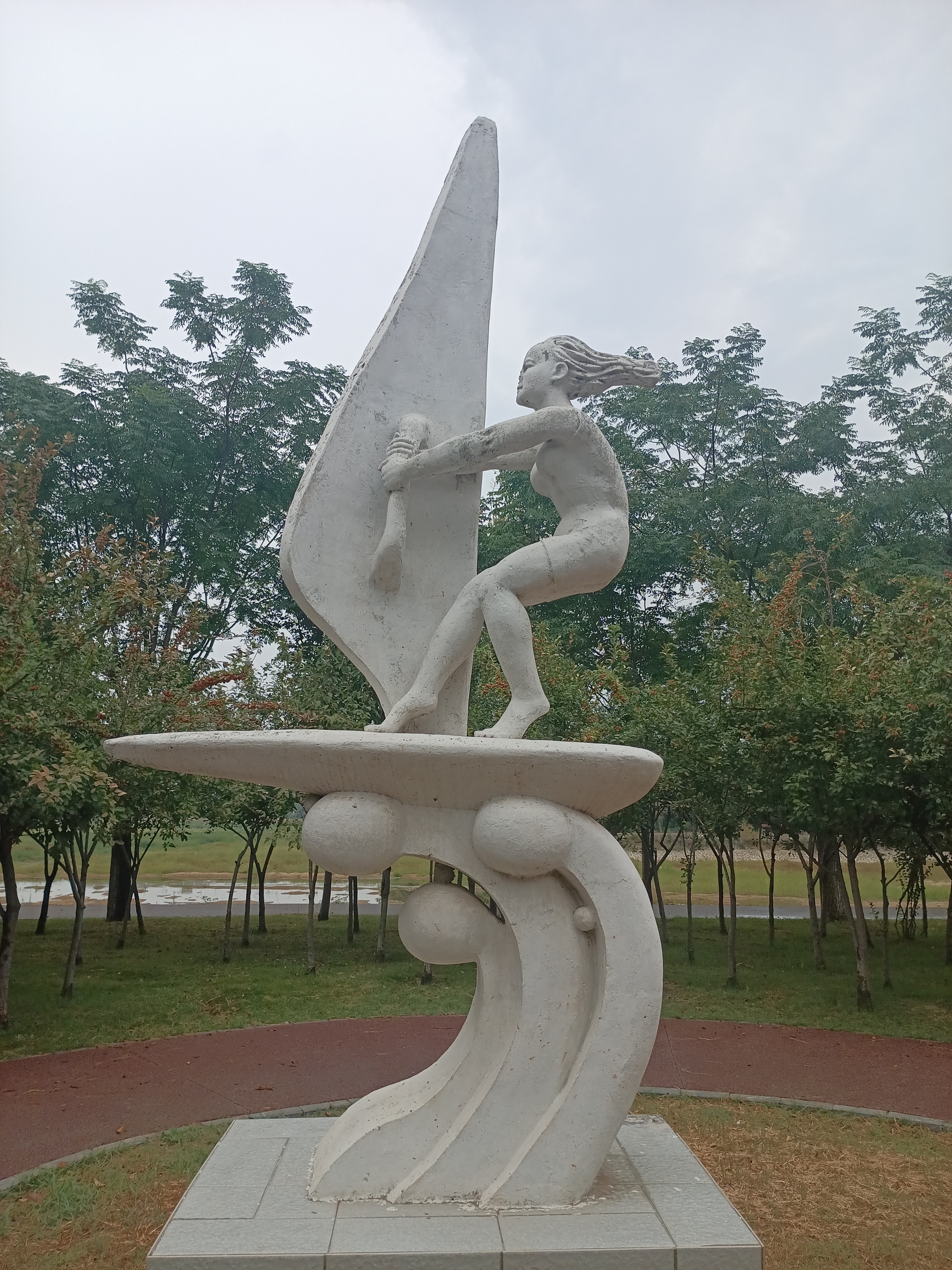 帆板踏浪：少女与风帆的浪漫邂逅，静谧公园中的艺术之美。