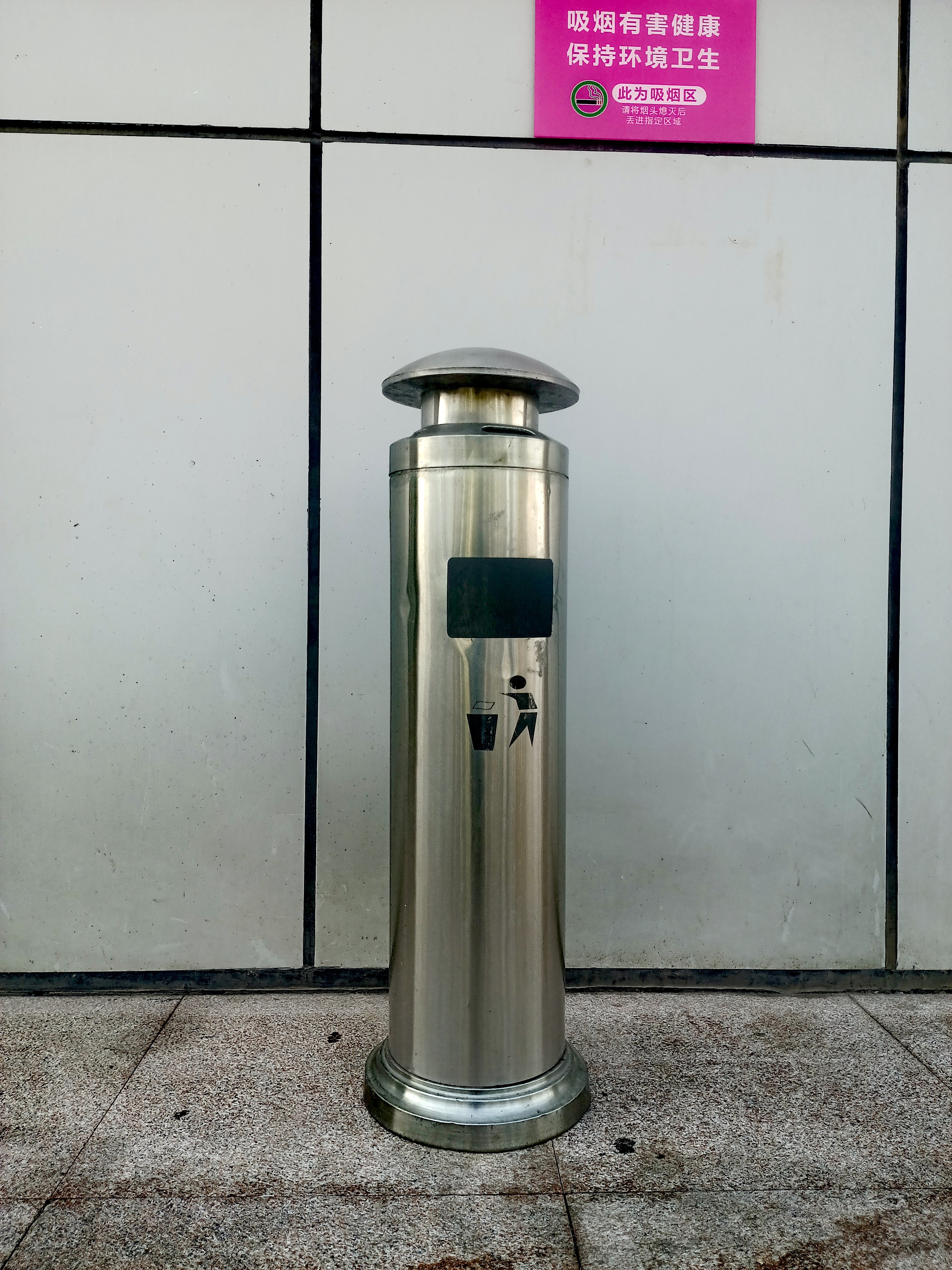 城市中的小确幸：
“保持环境卫生，此为吸烟区，”旁边立着个不锈钢烟灰桶，提醒着大家注意吸烟礼仪。烟头回收箱，守护环境卫生