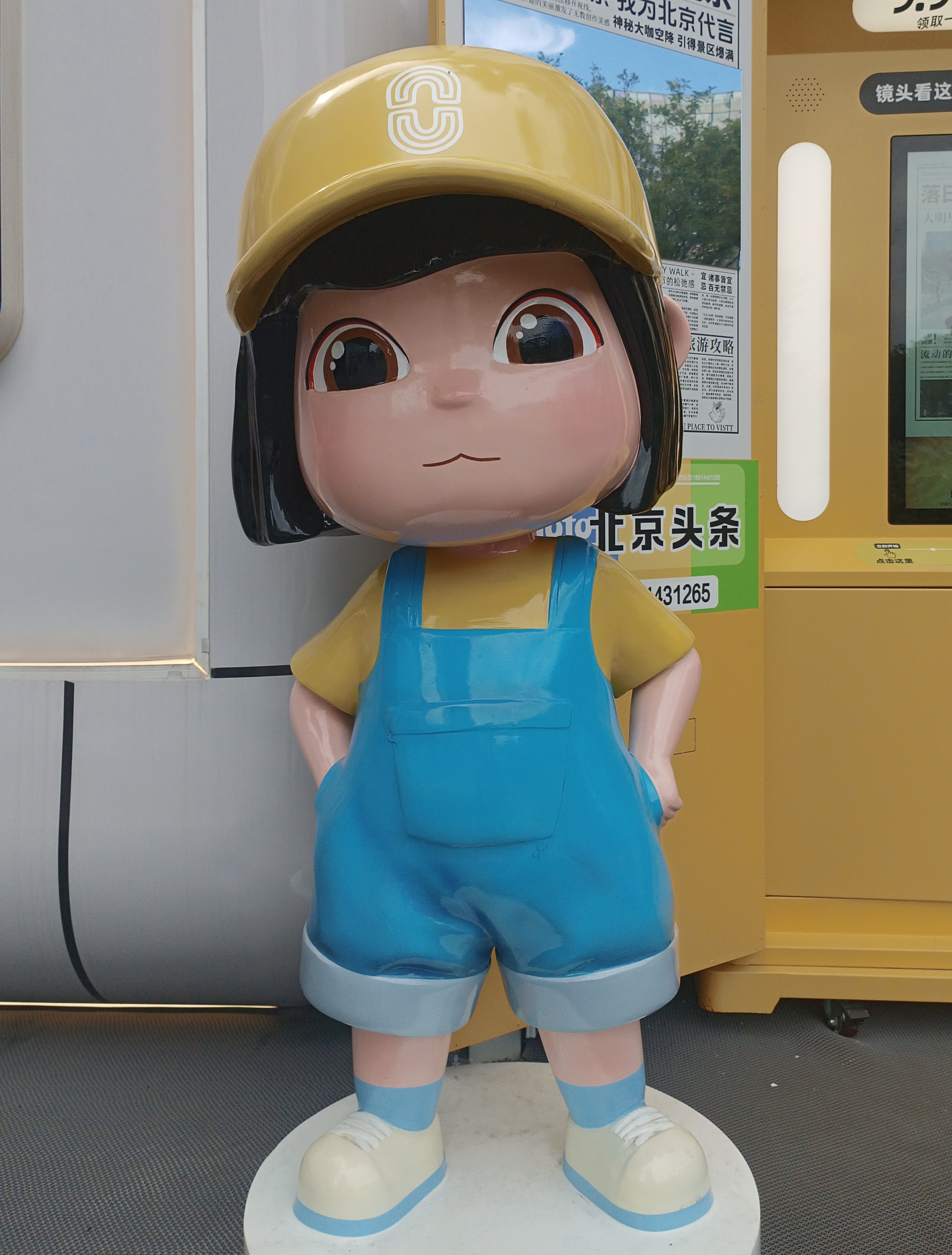 卡通人物雕塑：
萌趣的卡通人物，带着黄色帽子，穿着蓝色背带裤，可爱又惹人喜爱！