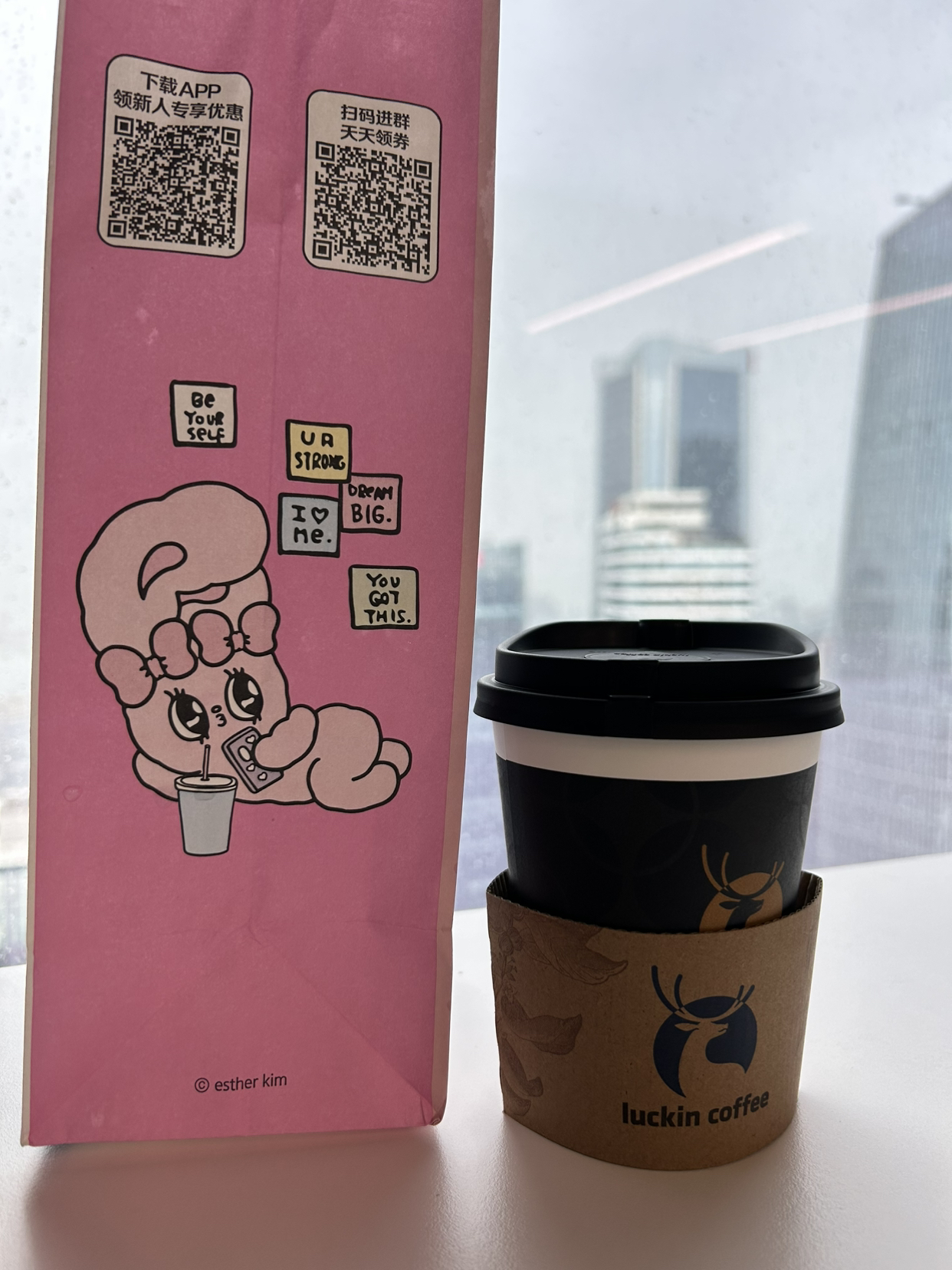 瑞幸的配送袋是 Esther Bunny（Esther Kim）联名海报的主题是：
“I'M THE BEST. MYSELF.”
副标语 “Be You. You’re Strong. Drink 