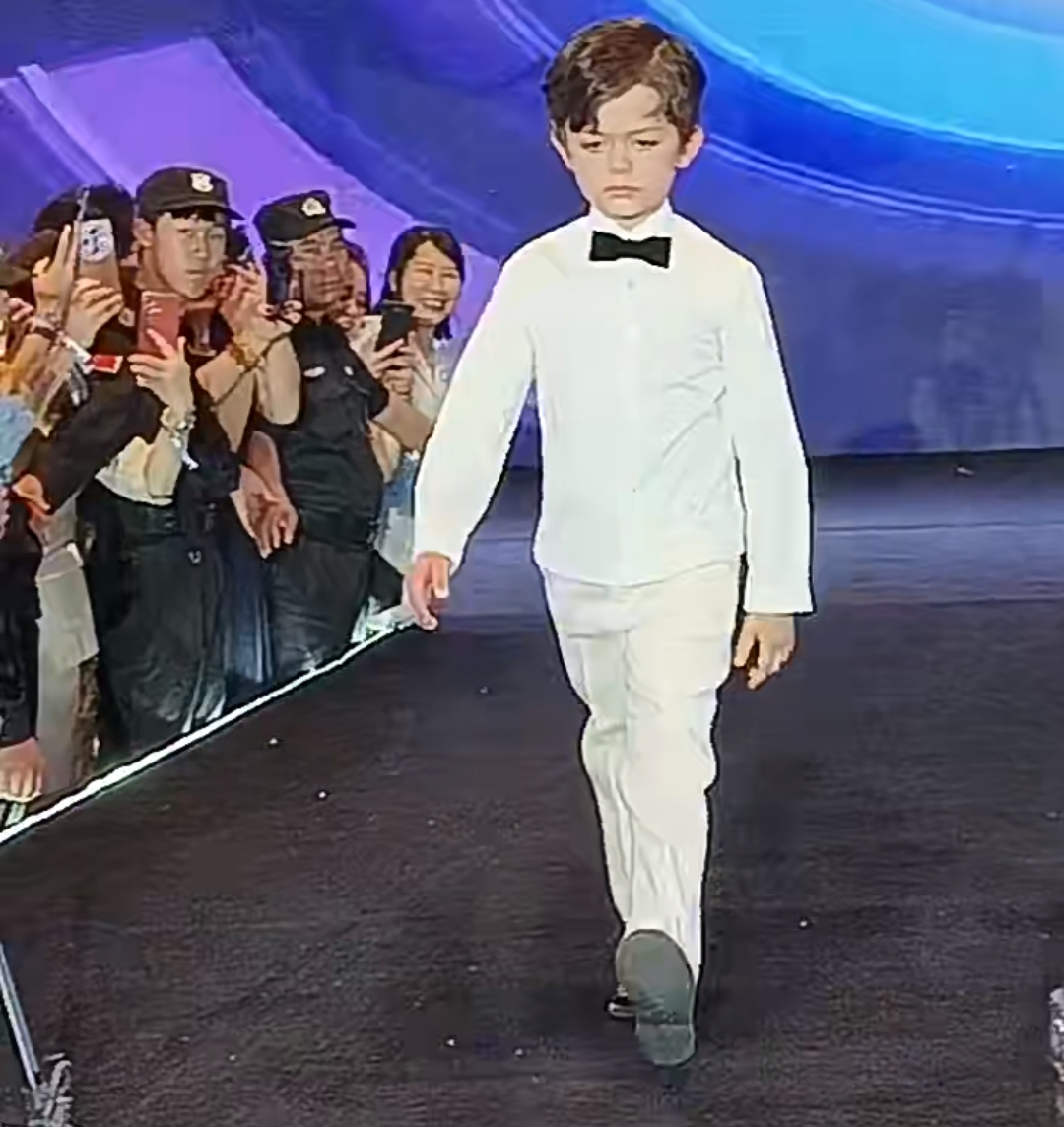 小宝台上走秀，虽然脸上依然没有什么笑容，但他很明显地跟妈妈于文红亲近了很多，因为