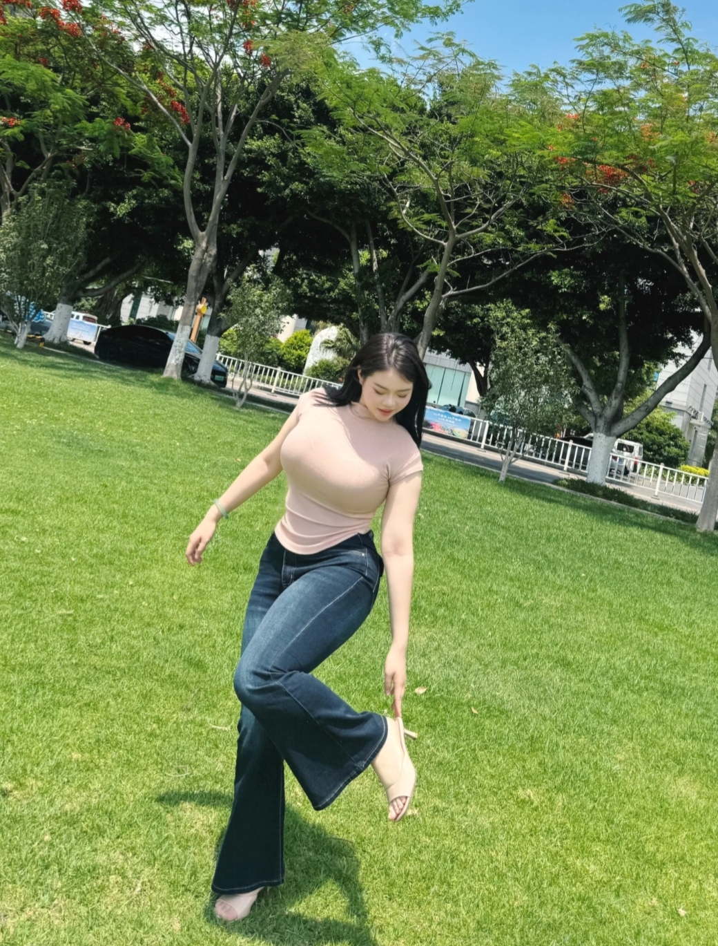 在夏日草坪，阳光吻着肌肤，浅粉上衣与牛仔喇叭裤，勾勒随性自在。风穿过发梢，脚步轻抬，把平凡日子，走成浪漫诗行 。